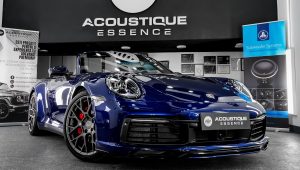 Porsche 911 Carrera 4S în fața logo-ului ACOUSTIQUE Essence, după detailing
